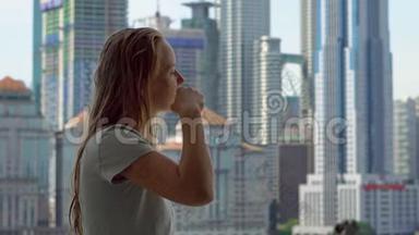 年轻女子刷牙站在阳台上，可以看到<strong>一座城市</strong>中心的摩天大楼
